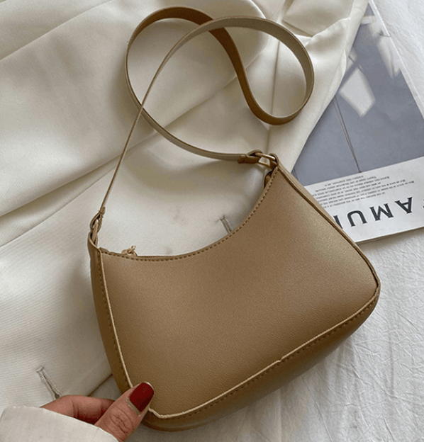 solo photo of a beige under the shoulder handbag on white background