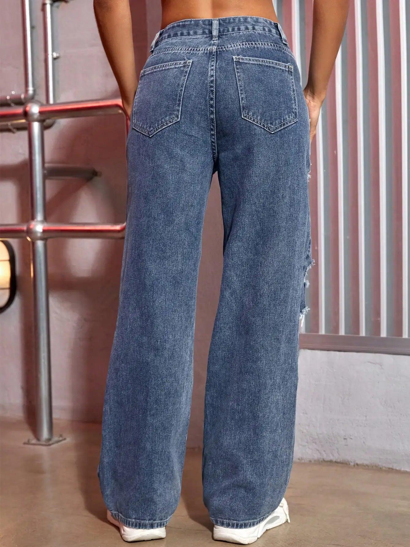 Woman wearing trendy blue baggy jeans with pocket details, photographed from the back in an industrial setting