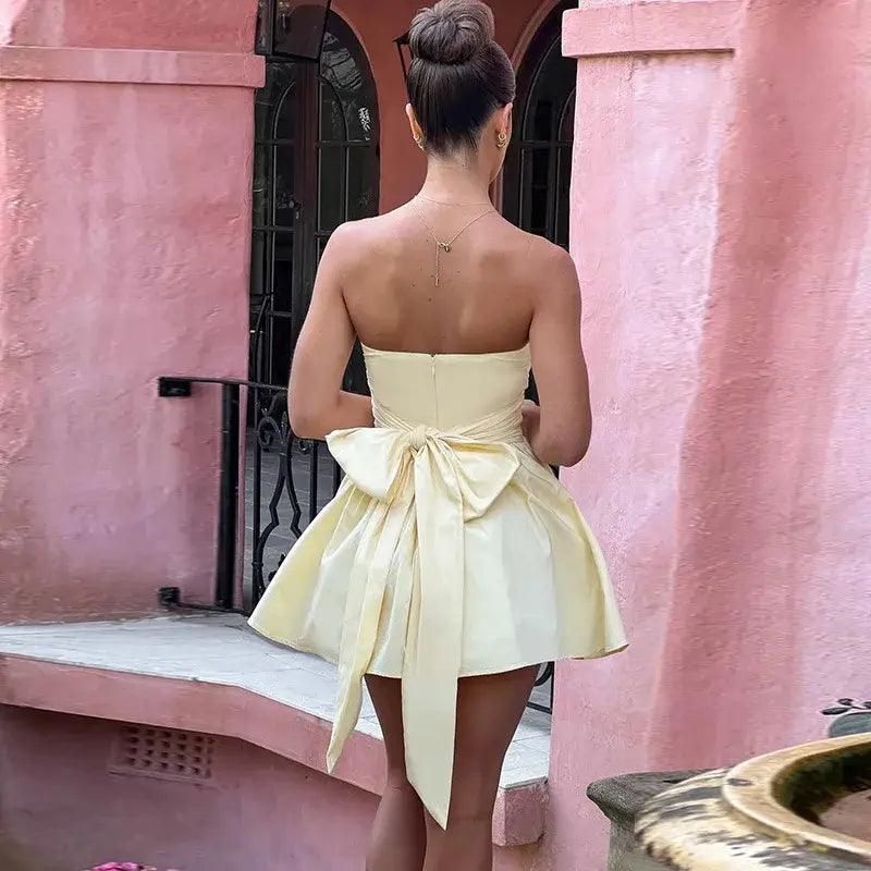 Woman wearing strapless mini dress with bow on the back